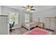 Light filled bedroom with a ceiling fan, neutral walls, wood floors, and two windows at 4825 Foxrun, Lakeland, FL 33813