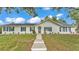 Inviting one-story home with a well-manicured lawn, blue shutters, and a charming front door with decorative glass at 4825 Foxrun, Lakeland, FL 33813