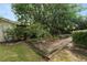 The backyard has a well maintained lawn, greenery, and a large tree at 509 Rob Roy St, Lakeland, FL 33813