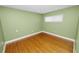 This bedroom features a light green color with hardwood floors and a window at 509 Rob Roy St, Lakeland, FL 33813