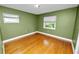 This bedroom features a light green color with hardwood floors and two windows at 509 Rob Roy St, Lakeland, FL 33813