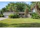 Inviting single-story home with a well-manicured lawn, mature trees, and a cozy bench on the front porch at 509 Rob Roy St, Lakeland, FL 33813