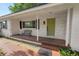 Welcoming front porch with brick flooring, a cozy bench, and a bright green front door at 509 Rob Roy St, Lakeland, FL 33813
