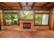 Cozy sunroom featuring brick floors, a brick fireplace and multiple view-enhancing windows at 509 Rob Roy St, Lakeland, FL 33813