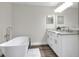 Bright bathroom featuring double sinks, granite countertops, white cabinets, and a freestanding tub at 5163 Spanish Oaks Dr, Lakeland, FL 33805