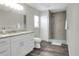 Bright bathroom featuring a granite countertop vanity, wood-look floors, and glass shower with grey tile at 5163 Spanish Oaks Dr, Lakeland, FL 33805