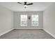 Spacious bedroom with carpet, a ceiling fan, and natural light from two windows at 5163 Spanish Oaks Dr, Lakeland, FL 33805