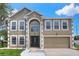 Charming two-story home with a manicured lawn and a two-car garage, featuring a classic architectural design at 5163 Spanish Oaks Dr, Lakeland, FL 33805