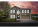 The house features a classic architecture, manicured lawn, and a two-car garage against a vibrant sky at 5163 Spanish Oaks Dr, Lakeland, FL 33805