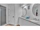 Bright bathroom with double sinks, white cabinetry, and walk in shower at 601 Peninsular Dr, Lakeland, FL 33813
