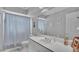 Well-lit bathroom features a single vanity, large mirror, and shower with curtain at 601 Peninsular Dr, Lakeland, FL 33813