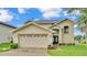 Charming two-story home with a well-manicured lawn and an attached two-car garage at 601 Peninsular Dr, Lakeland, FL 33813