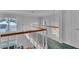 Second story hallway features a wood railing, natural light, and access to bedrooms at 601 Peninsular Dr, Lakeland, FL 33813