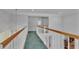 Upstairs hallway with carpet, wood railing, lighting fixtures, and natural light from the windows at 601 Peninsular Dr, Lakeland, FL 33813