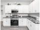 Well-lit kitchen with modern appliances, granite countertops, and classic white cabinets at 6060 Barracuda Loop, Wimauma, FL 33598