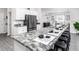 Kitchen island with barstools and granite countertops plus a refrigerator and white cabinets at 6060 Barracuda Loop, Wimauma, FL 33598