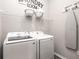 Functional laundry room equipped with modern washer and dryer units, plus ironing board at 6060 Barracuda Loop, Wimauma, FL 33598