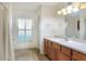 Well-lit bathroom with tile floors, a wood vanity, and a large mirror above the sink at 6065 Magpie Dr, Lakeland, FL 33809