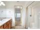 Bathroom featuring a sink with wood cabinetry, walk-in shower, and view of bedroom at 6065 Magpie Dr, Lakeland, FL 33809