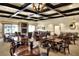 Spacious dining and lounge area featuring a fireplace, varied seating, and coffered ceilings at 6065 Magpie Dr, Lakeland, FL 33809