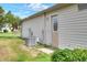 The home's exterior features an AC unit and a backyard with green grass and plants at 6065 Magpie Dr, Lakeland, FL 33809