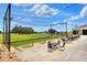 A putting green area with tables and chairs for relaxing; view of lush green landscaping and golf course at 6065 Magpie Dr, Lakeland, FL 33809