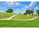 Scenic golf course view featuring lush green fairways and clear blue skies, with golf cart and players visible at 6065 Magpie Dr, Lakeland, FL 33809