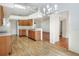Open-concept kitchen with wood cabinets, modern appliances, and adjacent dining area with chandelier at 6065 Magpie Dr, Lakeland, FL 33809