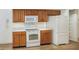 Bright kitchen with white appliances, wood cabinets, and laminate flooring at 6065 Magpie Dr, Lakeland, FL 33809