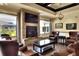 Comfortable lounge area with stone fireplace, TV, and supple leather chairs for easy relaxation at 6065 Magpie Dr, Lakeland, FL 33809
