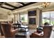 Relaxing lounge area with a stone fireplace, TV, comfortable leather chairs, and plenty of natural light at 6065 Magpie Dr, Lakeland, FL 33809