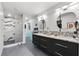 Modern bathroom featuring double vanities, granite counters, and a glass enclosed shower at 6250 Silver Leaf Ln, Lakeland, FL 33813