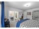 Comfortable bedroom featuring a large bed with patterned bedding, a modern dresser, and access to an outdoor area at 6250 Silver Leaf Ln, Lakeland, FL 33813