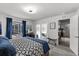Bright bedroom with a large bed, patterned bedding, and a sliding glass door leading to an outdoor space at 6250 Silver Leaf Ln, Lakeland, FL 33813
