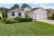 Inviting single-Gathering home featuring an attached two-car garage, lush lawn, and trimmed shrubs at 6250 Silver Leaf Ln, Lakeland, FL 33813