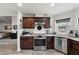 Modern kitchen features stainless steel appliances, dark wood cabinets, granite countertops, and wood-look tile flooring at 6250 Silver Leaf Ln, Lakeland, FL 33813