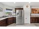 Stainless steel refrigerator with dark wood cabinets, granite countertops, and modern fixtures create an elegant kitchen space at 6250 Silver Leaf Ln, Lakeland, FL 33813