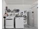 Bright laundry area featuring modern washer and dryer, storage shelves, and a water heater at 6250 Silver Leaf Ln, Lakeland, FL 33813