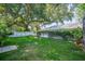 Serene backyard with a sprawling green lawn, privacy fence, and mature trees providing ample shade at 645 E Church St, Bartow, FL 33830