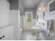 Bright bathroom featuring a window, pedestal sink, and classic tiled floors at 645 E Church St, Bartow, FL 33830
