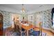 Elegant dining room with vintage wallpaper, hardwood flooring, and view of a grand piano at 645 E Church St, Bartow, FL 33830