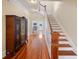 Inviting foyer with hardwood floors and staircase, accented by an antique cabinet, leads to the upper level at 645 E Church St, Bartow, FL 33830