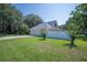 Three-car garage with a large driveway, surrounded by a well-manicured lawn and lush landscaping at 645 E Church St, Bartow, FL 33830