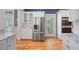 Bright kitchen featuring stainless steel refrigerator and appliances, complemented by white cabinetry and hardwood flooring at 645 E Church St, Bartow, FL 33830
