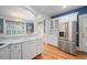 This bright kitchen features stainless steel appliances and marble countertops, complemented by hardwood floors and white cabinets at 645 E Church St, Bartow, FL 33830