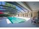 Screened in pool and jacuzzi with white patio furniture at 645 E Church St, Bartow, FL 33830