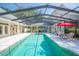 Enclosed pool area with screen enclosure, patio furniture, and lush landscaping at 645 E Church St, Bartow, FL 33830