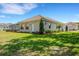 Back exterior view of home featuring screened in lanai, lush green lawn, and well maintained landscaping at 6527 Eagle Ridge Way, Lakeland, FL 33813