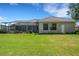 Well-manicured backyard featuring a screened patio with outdoor seating and lush grass at 6527 Eagle Ridge Way, Lakeland, FL 33813