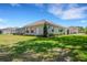 Back exterior view of home featuring screened in lanai, lush green lawn, and well maintained landscaping at 6527 Eagle Ridge Way, Lakeland, FL 33813